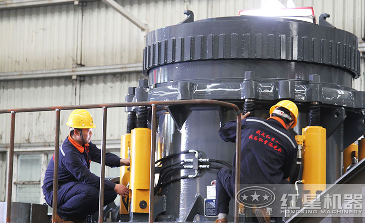 工作人员检测圆锥破碎机，保障生产的设备都有高质量